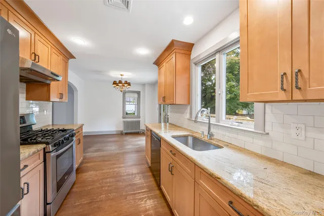 a kitchen with granite countertop a sink and a stove