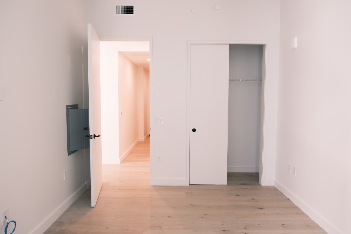 610 Davis Street, Unit 2708 Austin, TX 78701 - Photo 14 of 40 Unfurnished bedroom with light wood-type flooring, a closet, and electric panel