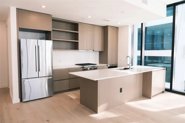 a kitchen with stainless steel appliances a refrigerator sink and cabinets
