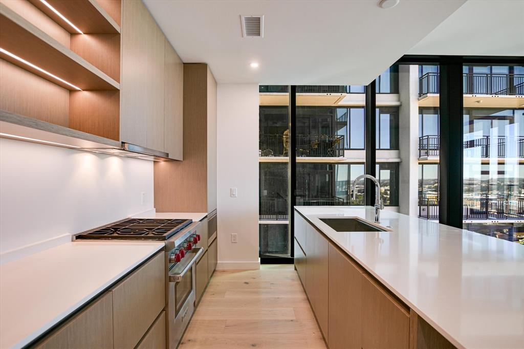 610 Davis Street, Unit 2708 Austin, TX 78701 - Photo 4 of 35 a kitchen with stainless steel appliances granite countertop a sink and a refrigerator
