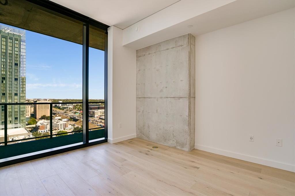 610 Davis Street, Unit 2708 Austin, TX 78701 - Photo 7 of 35 Empty room featuring a wall of windows, a view of city, and wood finished floors
