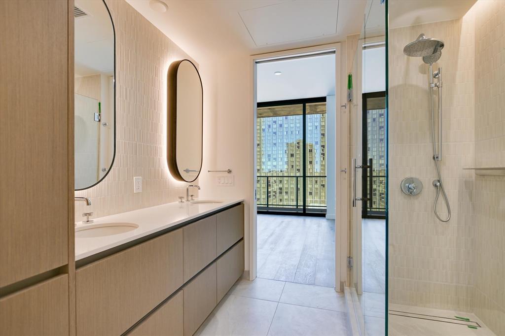 610 Davis Street, Unit 2708 Austin, TX 78701 - Photo 8 of 35 Full bath featuring expansive windows, double vanity, a walk in shower, and light tile patterned floors