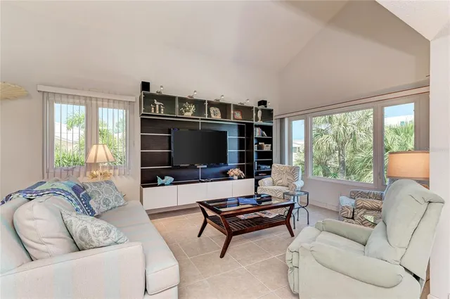 a living room with furniture a flat screen tv and a large window