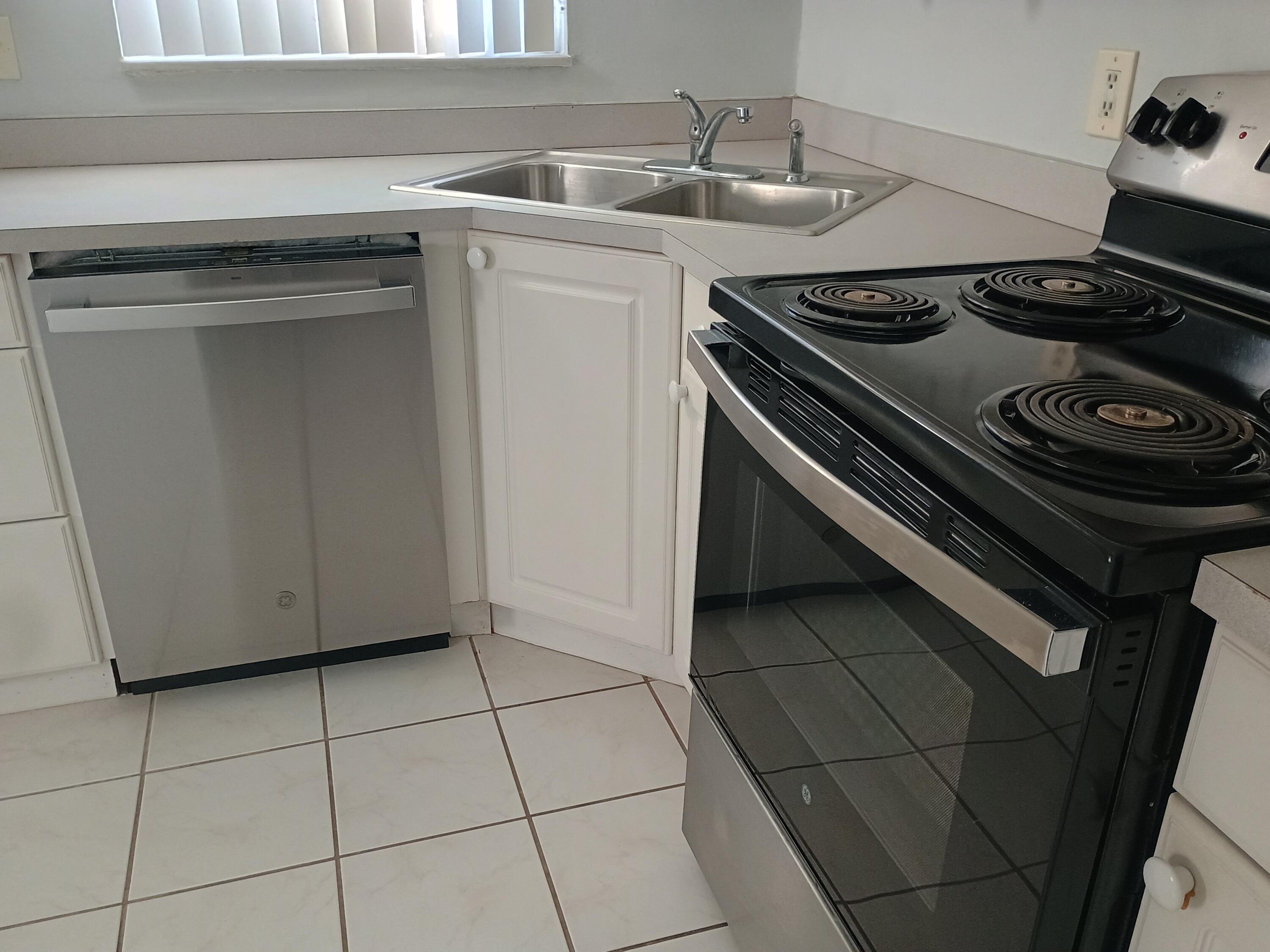 3 Colonial Club Drive, Unit 100 Boynton Beach, FL 33435 - Photo 8 of 26 a stove top oven sitting inside of a kitchen