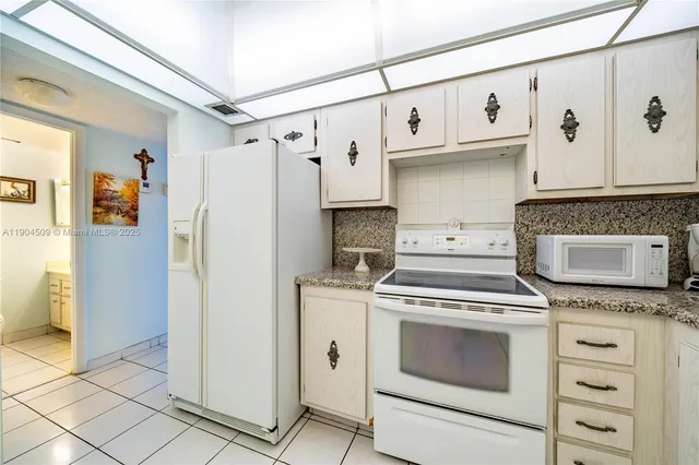 a kitchen with stainless steel appliances white cabinets and wooden floor