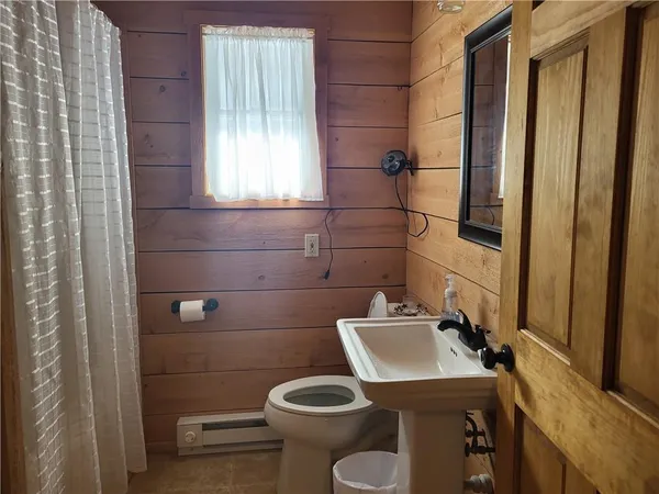 a bathroom with a toilet a sink and mirror