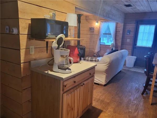a living room with furniture a flat screen tv and kitchen view