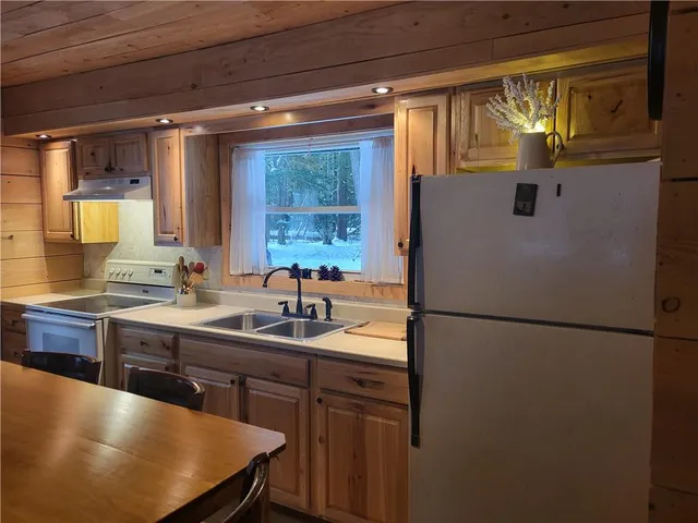 a kitchen with a sink a refrigerator a stove and a refrigerator