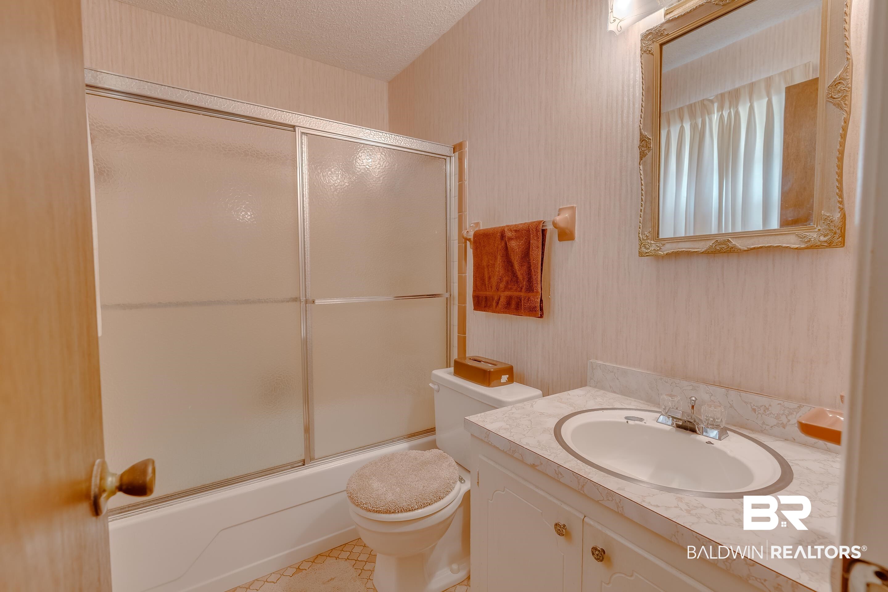 5151 McCrary Road Semmes, AL 36575 - Photo 54 of 62 Bathroom featuring toilet, shower / bath combination with glass door, vanity, and a textured ceiling