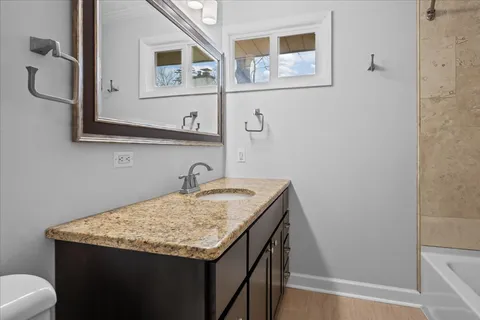 a bathroom with a granite countertop sink and a mirror