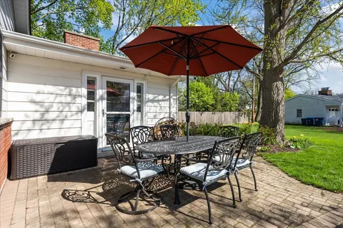 a view of a patio with table and chairs under an umbrella