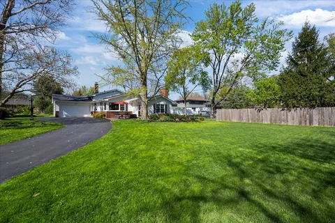 a view of a backyard with table and chairs and a large tree