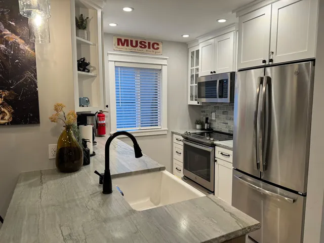 a kitchen with stainless steel appliances granite countertop a refrigerator and a sink