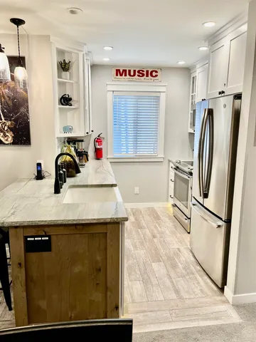 a kitchen with granite countertop a sink and a refrigerator
