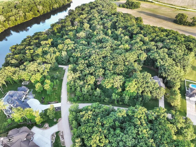 an aerial view of residential houses with outdoor space and lakeside