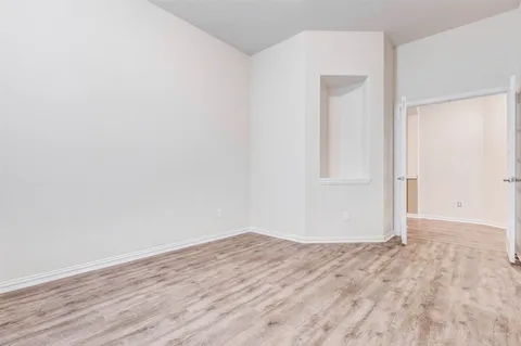 a large white kitchen with kitchen island a sink dishwasher a stove and a refrigerator with wooden floor