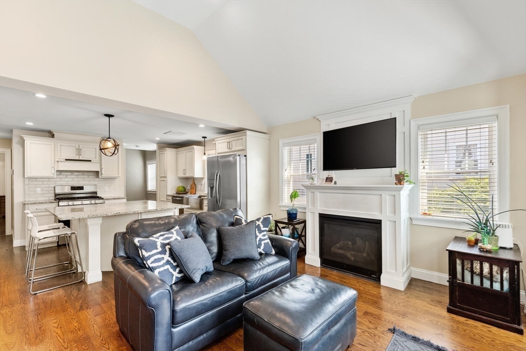23 Locust Street, Unit 2 Danvers, MA 01923 - Photo 11 of 32 a living room with furniture a fireplace and a flat screen tv