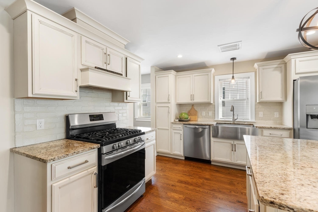 23 Locust Street, Unit 2 Danvers, MA 01923 - Photo 3 of 32 a kitchen with stainless steel appliances granite countertop a stove and a refrigerator