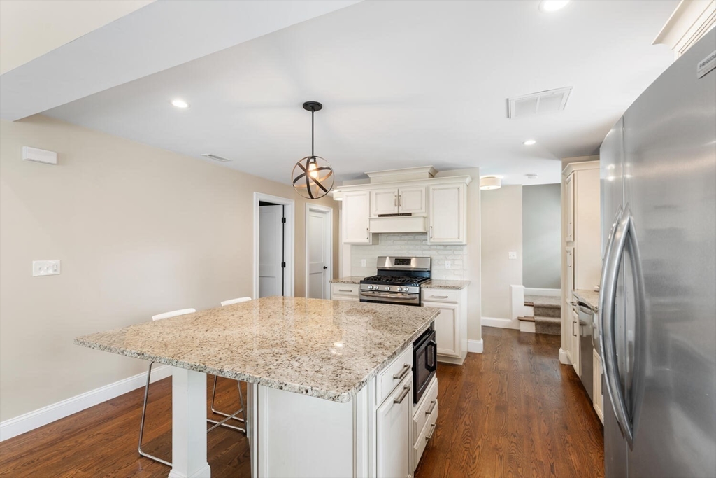 23 Locust Street, Unit 2 Danvers, MA 01923 - Photo 5 of 32 a kitchen with stainless steel appliances granite countertop a sink refrigerator and cabinets