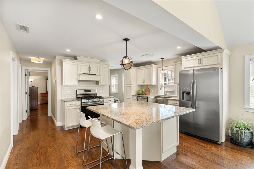 23 Locust Street, Unit 2 Danvers, MA 01923 - Photo 8 of 32 a kitchen with stainless steel appliances granite countertop a sink stove and refrigerator