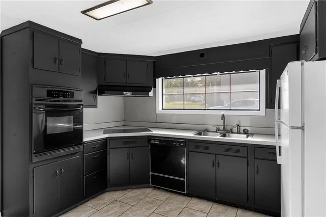 a kitchen with a refrigerator sink and cabinets