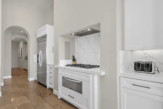 a kitchen with cabinets and steel stove
