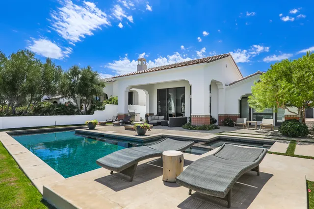 a view of a house with swimming pool and sitting area