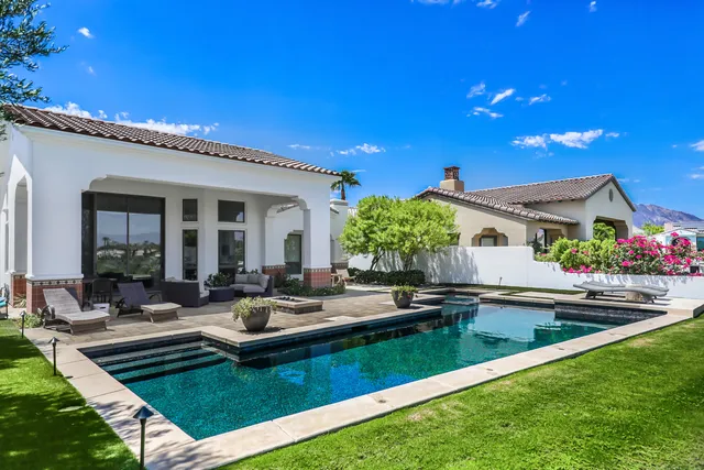 a view of a house with swimming pool and sitting area