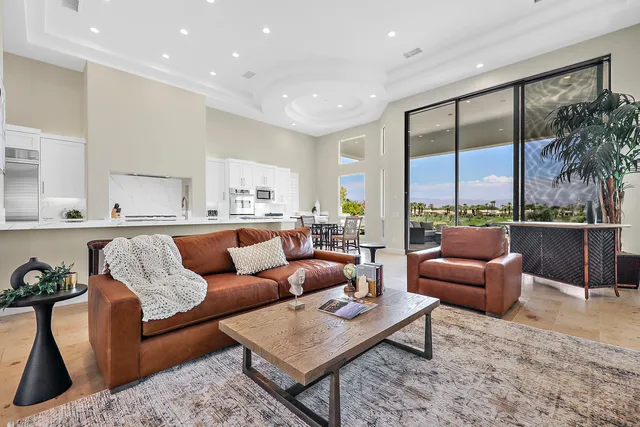 a living room with furniture ceiling fan and a large window