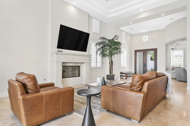 a living room with furniture a flat screen tv and a fireplace