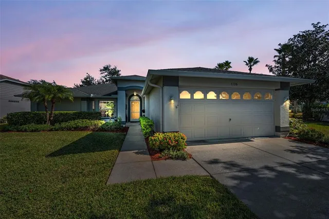 a front view of a house with a yard and a garage