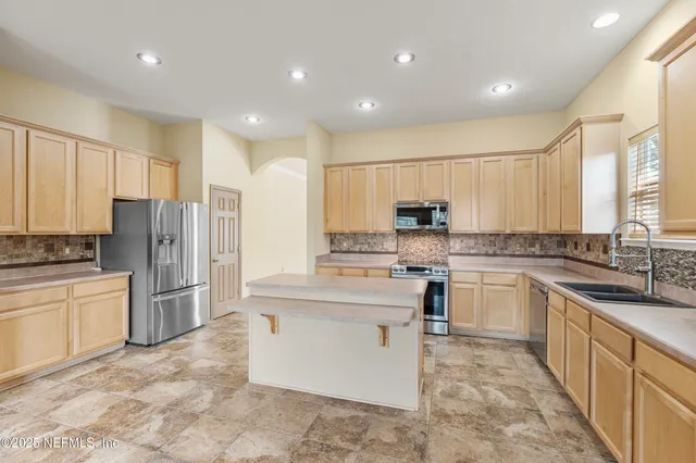 a kitchen with stainless steel appliances granite countertop a refrigerator sink and cabinets