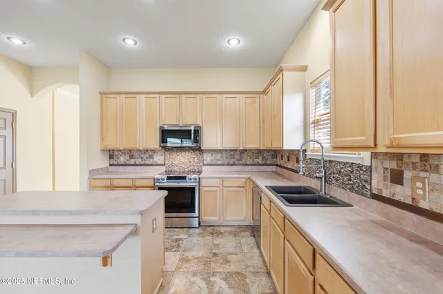 a kitchen with a stove a sink and a refrigerator