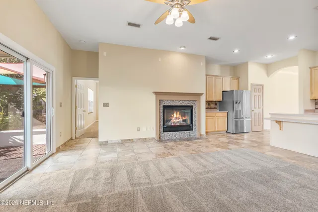 a view of an empty room with a fireplace and a window