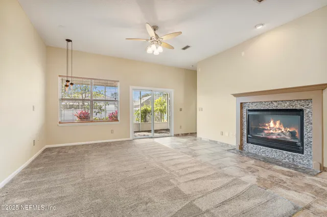 an empty room with windows and fireplace