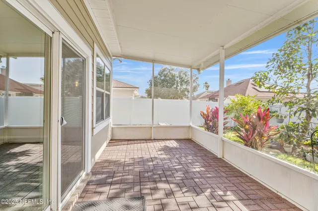 a patio with table and chairs and potted plants