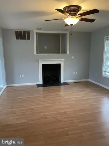 a view of an empty room with a fireplace and a window