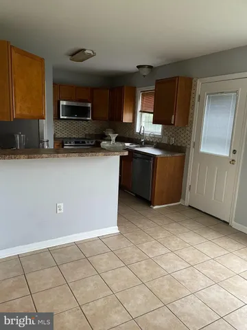 a kitchen with stainless steel appliances granite countertop a sink a stove a microwave a counter top space and cabinets