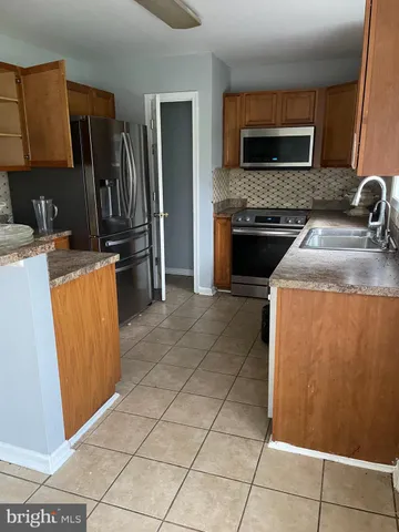 a kitchen with granite countertop a refrigerator and a stove top oven