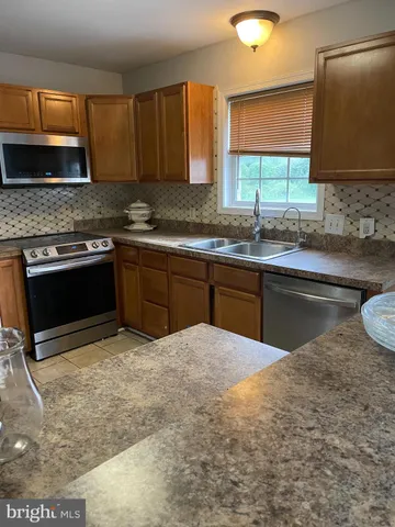 a kitchen with granite countertop a sink and a stove top oven