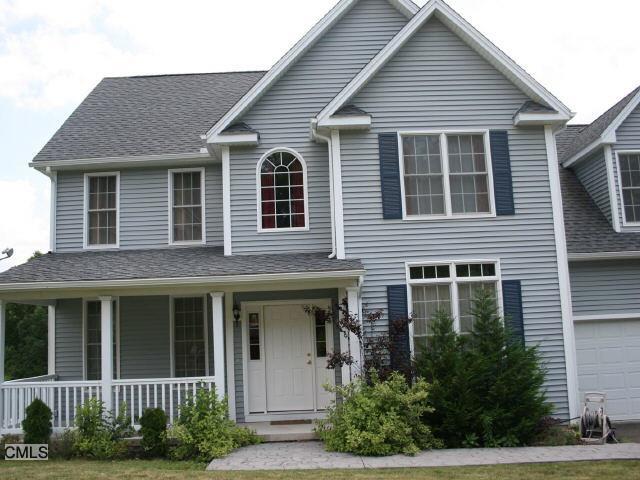 a front view of a house with plants and trees