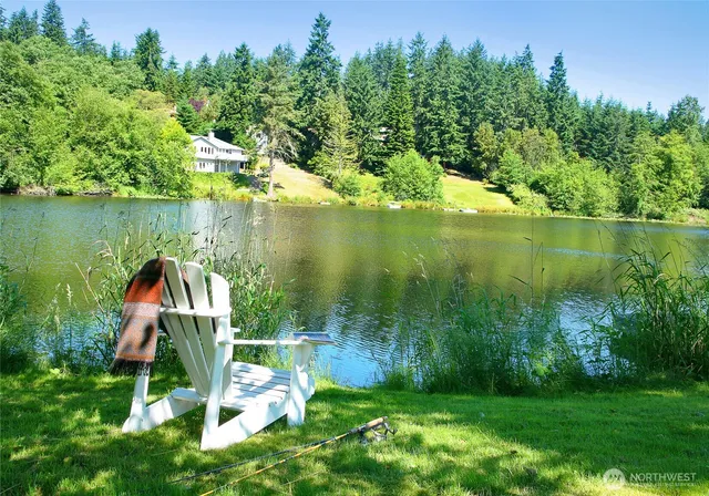 a view of a lake with a yard and large trees