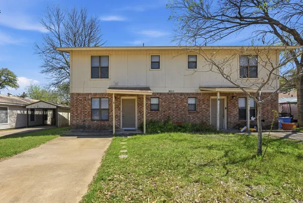 a view of a brick house with a yard