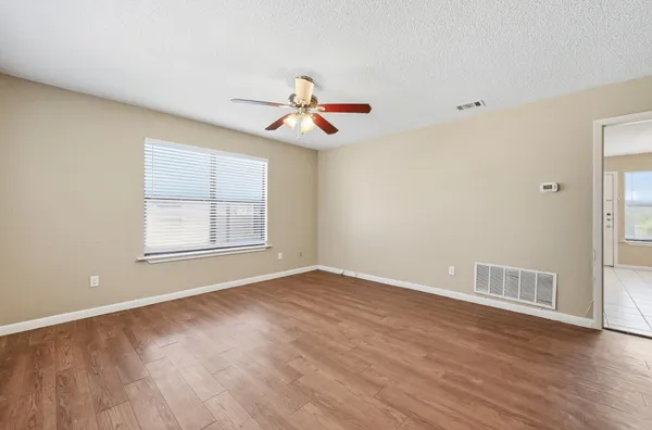 wooden floor in an empty room with a window