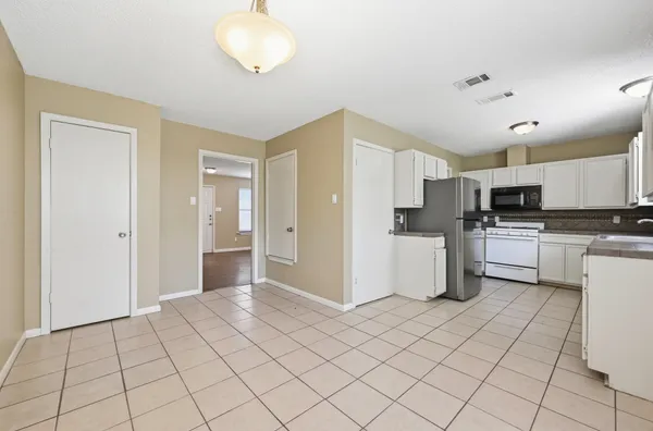 a kitchen with white cabinets and white appliances