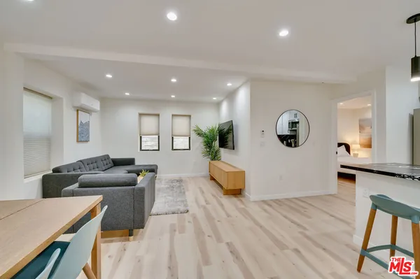 a living room with furniture and a wooden floor