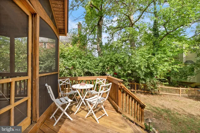 a patio with table and chairs and potted plants