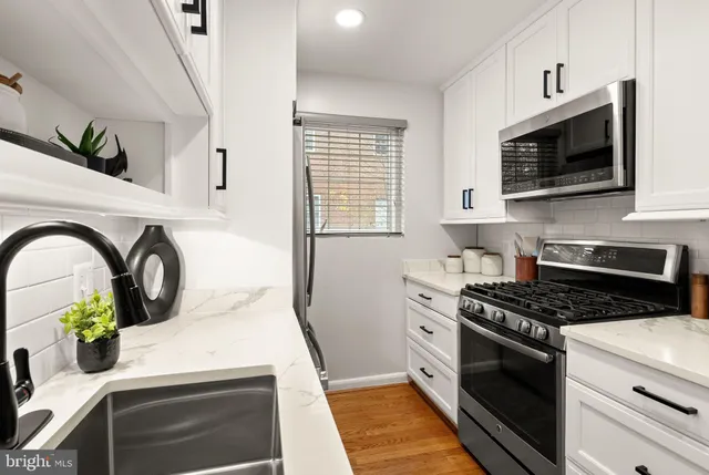 a kitchen with white cabinets and appliances
