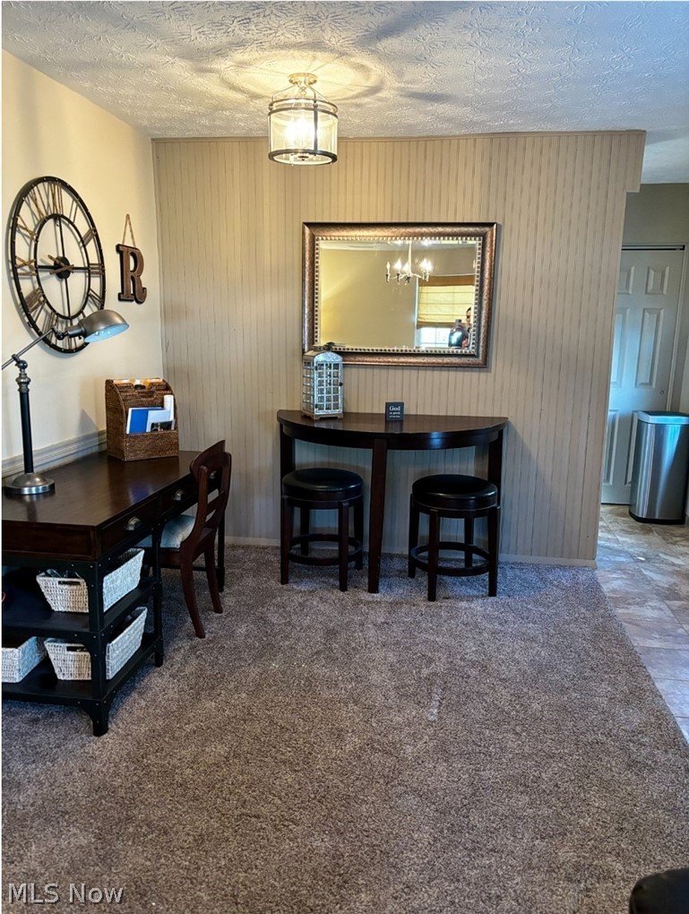 2514 Raber Road, Unit 4A Uniontown, OH 44685 - Photo 5 of 13 Dining area with an inviting chandelier, carpet floors, and a textured ceiling