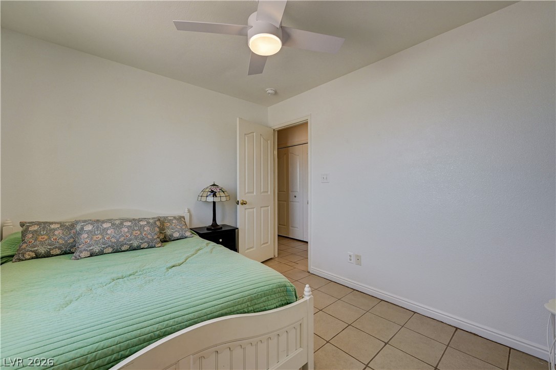 1272 Liston Avenue Logandale, NV 89021 - Photo 27 of 61 A comfortable bedroom features cool tile flooring and a ceiling fan for year-round comfort.